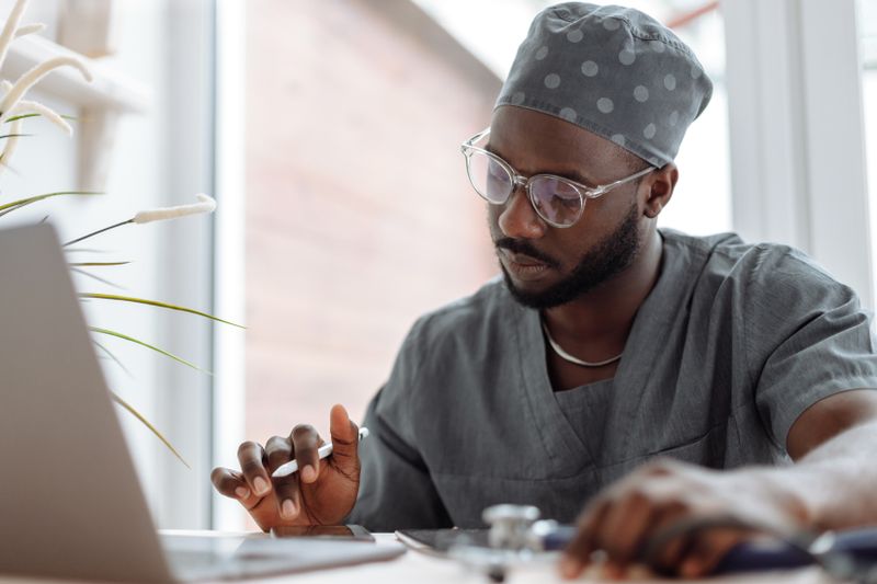 Andre Cole reviewing notes beside a laptop